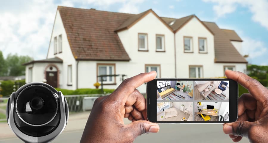 Man holding mobile device and looking at footage from security cameras